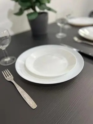 a white plate and a fork on a table at Thiseio Residence- Studio 55 in Athens