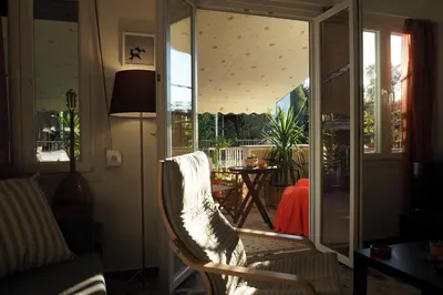 a living room with a chair and a sliding glass door at Cicada 's Song in Athens