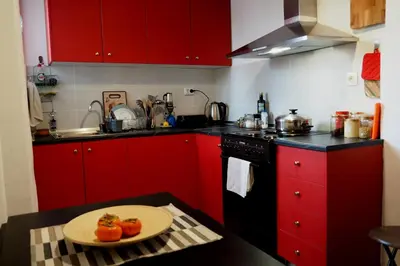 a kitchen with red cabinets and a plate on a table at Cicada 's Song in Athens