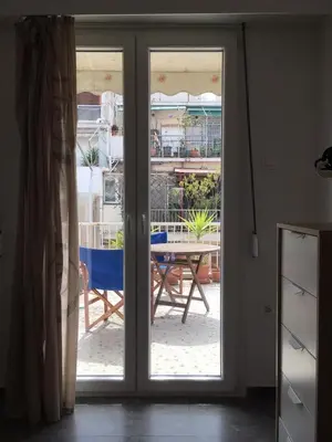a sliding glass door leading to a patio with a table at Cicada 's Song in Athens