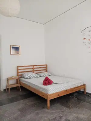 a bed with a red hat on top of it at Cicada 's Song in Athens