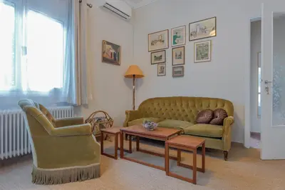 a living room with a couch and two chairs and a table at Vintage-style Garden Apartment in Athens