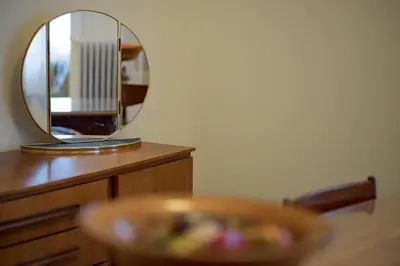 a mirror sitting on top of a wooden dresser at Vintage-style Garden Apartment in Athens