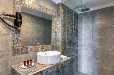a bathroom with a sink and a mirror at Arcade Hotel Athens in Athens