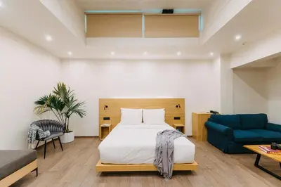 a bedroom with a bed and a blue couch at Arcade Hotel Athens in Athens
