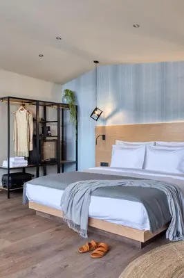 a bedroom with a large bed with shoes on the floor at Arcade Hotel Athens in Athens
