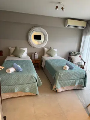 a bedroom with two beds and a mirror at Sophia's apartment in Saronida