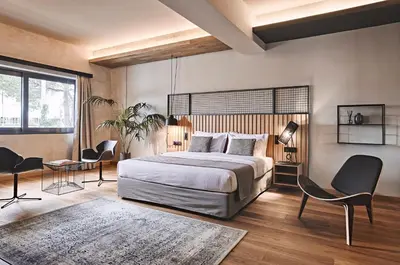 a bedroom with a bed and a table and chairs at Cama Luxury Suites Glyfada in Athens