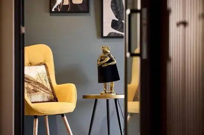 a room with two chairs and a statue on a stool at Cama Luxury Suites Glyfada in Athens