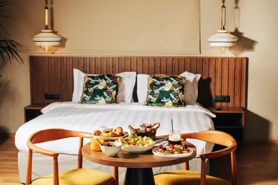 a hotel room with a bed and a table with food on it at Cama Luxury Suites Glyfada in Athens