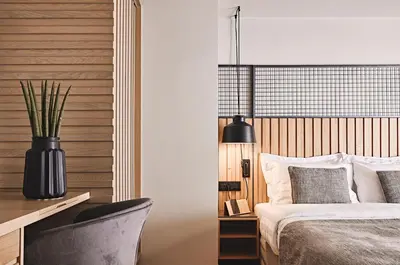 a bedroom with a bed and a desk with a lamp at Cama Luxury Suites Glyfada in Athens