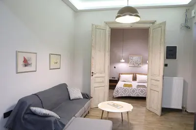 a living room with a couch and a bed at Όμορφο διαμέρισμα σε διατηρητέο κτίσμα στην Αθήνα in Athens