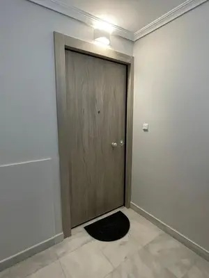 a door with a black door mat in a room at Kalimera Alimos Apartment in Athens
