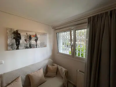 a living room with a couch and a window at Kalimera Alimos Apartment in Athens