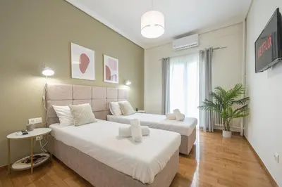 a bedroom with two beds and a table and a window at The 