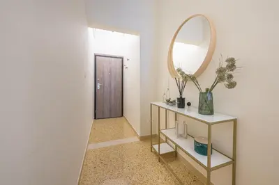 a hallway with a mirror and a table with a shelf at The 