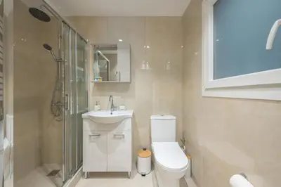 a bathroom with a toilet and a sink and a shower at The 