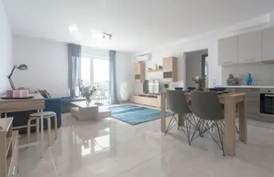 a kitchen and living room with a table and chairs at New spacious apartment located in Piraeus in Piraeus