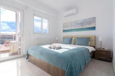a white bedroom with a large bed and a window at New spacious apartment located in Piraeus in Piraeus