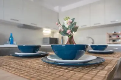 a kitchen with three blue bowls and a vase with flowers at New spacious apartment located in Piraeus in Piraeus