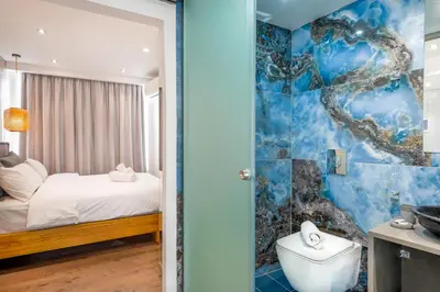 a bedroom with a bed and a bathroom with a toilet at Stylish Living-Parthenon in Athens