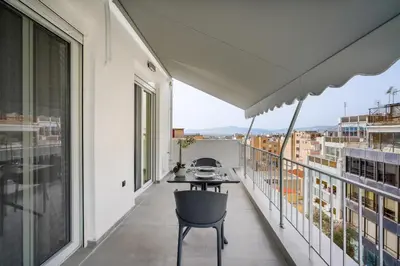 a balcony with a table and chairs on a building at Stylish Living-Parthenon in Athens