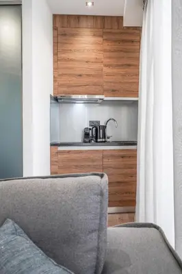 a living room with a couch and a kitchen at Stylish Living-Parthenon in Athens