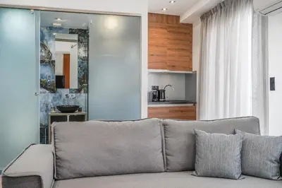 a living room with a couch and a kitchen at Stylish Living-Parthenon in Athens