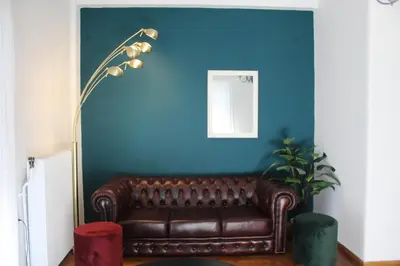 a brown leather couch in a room with a blue wall at Suite 2 Bedrooms in Athens