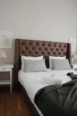 a bedroom with a large bed with a leather headboard at Suite 2 Bedrooms in Athens