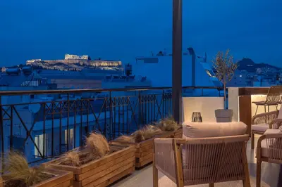 a balcony with chairs and a view of a city at Parthenon Dream, breathtaking views with massage chair in Athens