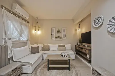 a living room with a white couch and a table at Stylish Apartment at Pagrati in Athens
