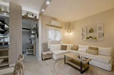 a living room with a white couch and a table at Stylish Apartment at Pagrati in Athens