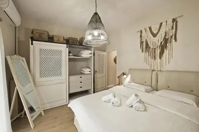 a bedroom with two white beds and a chandelier at Stylish Apartment at Pagrati in Athens