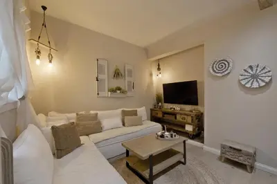 a living room with a white couch and a tv at Stylish Apartment at Pagrati in Athens
