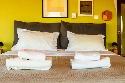 a bed with three towels on top of it at Lis153 by Smart Cozy Suites - Top Floors with Amazing City View - Available 24hr in Athens