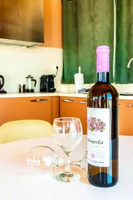 a bottle of wine sitting next to a wine glass at Lis153 by Smart Cozy Suites - Top Floors with Amazing City View - Available 24hr in Athens