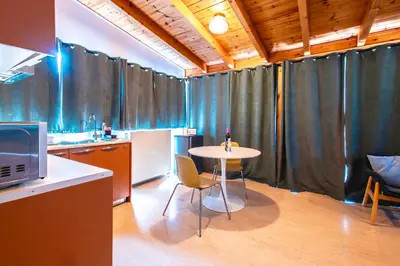 a kitchen with a table in a room with curtains at Lis153 by Smart Cozy Suites - Top Floors with Amazing City View - Available 24hr in Athens