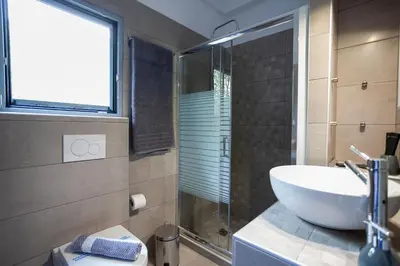 a bathroom with a sink and a glass shower at Landscape luxury flat Psyrri square in Athens
