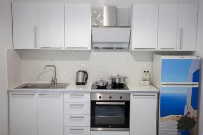 a kitchen with white cabinets and a stove and a refrigerator at Landscape luxury flat Psyrri square in Athens