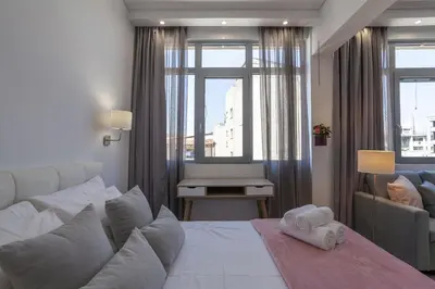 a bedroom with a bed and a couch and a window at Fedias Luxury flat Psyrri square in Athens