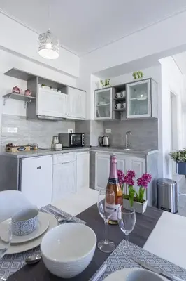 a kitchen with a table with a bottle of wine at Fedias Luxury flat Psyrri square in Athens