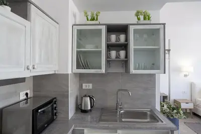 a kitchen with white cabinets and a sink at Fedias Luxury flat Psyrri square in Athens