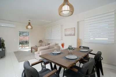 a dining room with a wooden table and chairs at Ozone Complex by A&D Properties in Porto Rafti