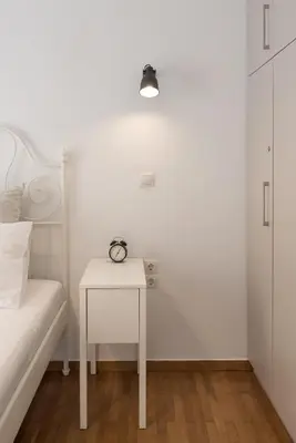 a white bedroom with a bed and a white table at Amazing apartment 2 min to Acropolis in Athens