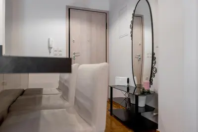 a white bathroom with a mirror and a couch at Amazing apartment 2 min to Acropolis in Athens
