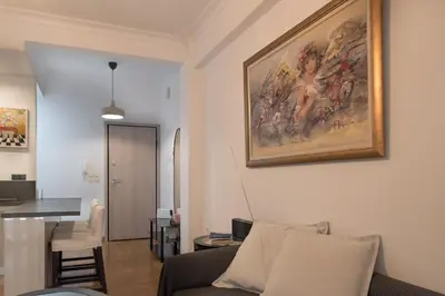 a living room with a couch and a painting on the wall at Amazing apartment 2 min to Acropolis in Athens