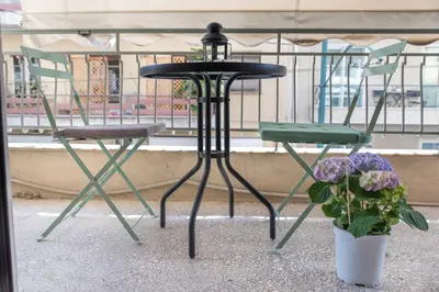 two chairs and a table and a vase with flowers at Amazing apartment 2 min to Acropolis in Athens