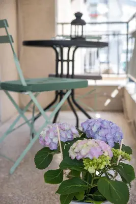 a vase with purple flowers in front of a table at Amazing apartment 2 min to Acropolis in Athens