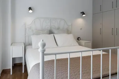 a bedroom with a white bed with a white rail at Amazing apartment 2 min to Acropolis in Athens